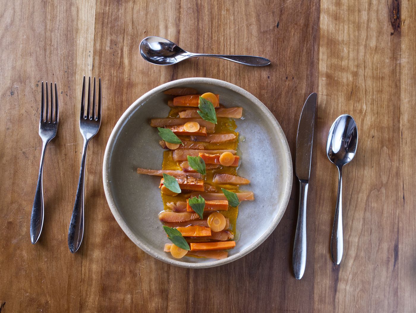 Plat de saison aux carottes glacées, poisson fumé et herbes